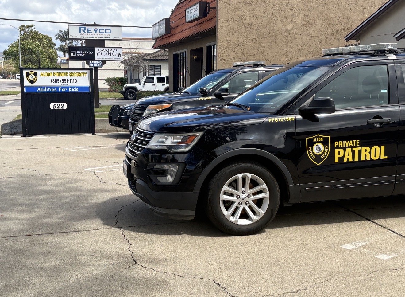 Alcon Private Security vehicles outside the company office and roadside sign
