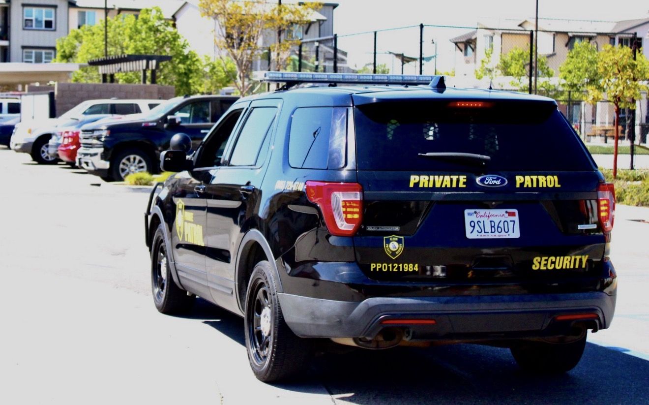 Rear view of an Alcon Private Patrol SUV at an apartment community