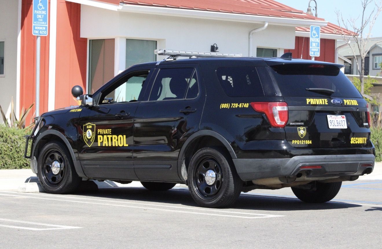 Side view of a marked Alcon Private Patrol SUV in a parking lot